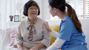 Older adult receives help with medication at a bright assisted living apartment.