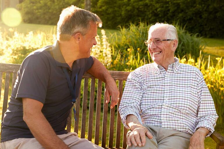 Older adult and family member reviewing care options at a table with a nurse nearby.